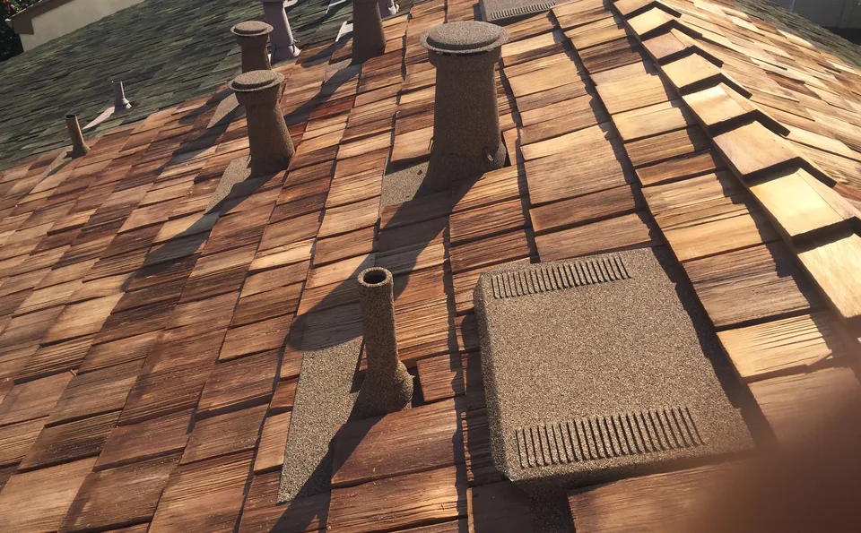 Stone coated vents and a flat vent on a wood shake roof